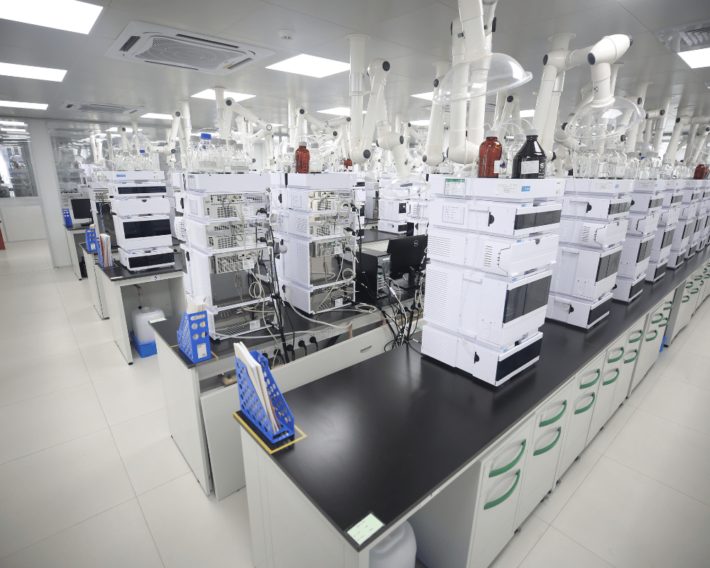 Analytical development laboratory filled with white HPLC analytical chromatography instruments on black benchtops.